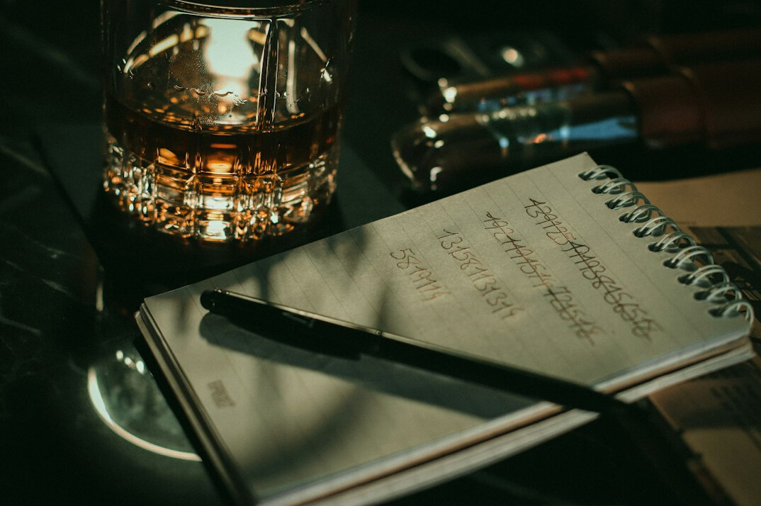 Open notebook with handwritten code notes and a pen